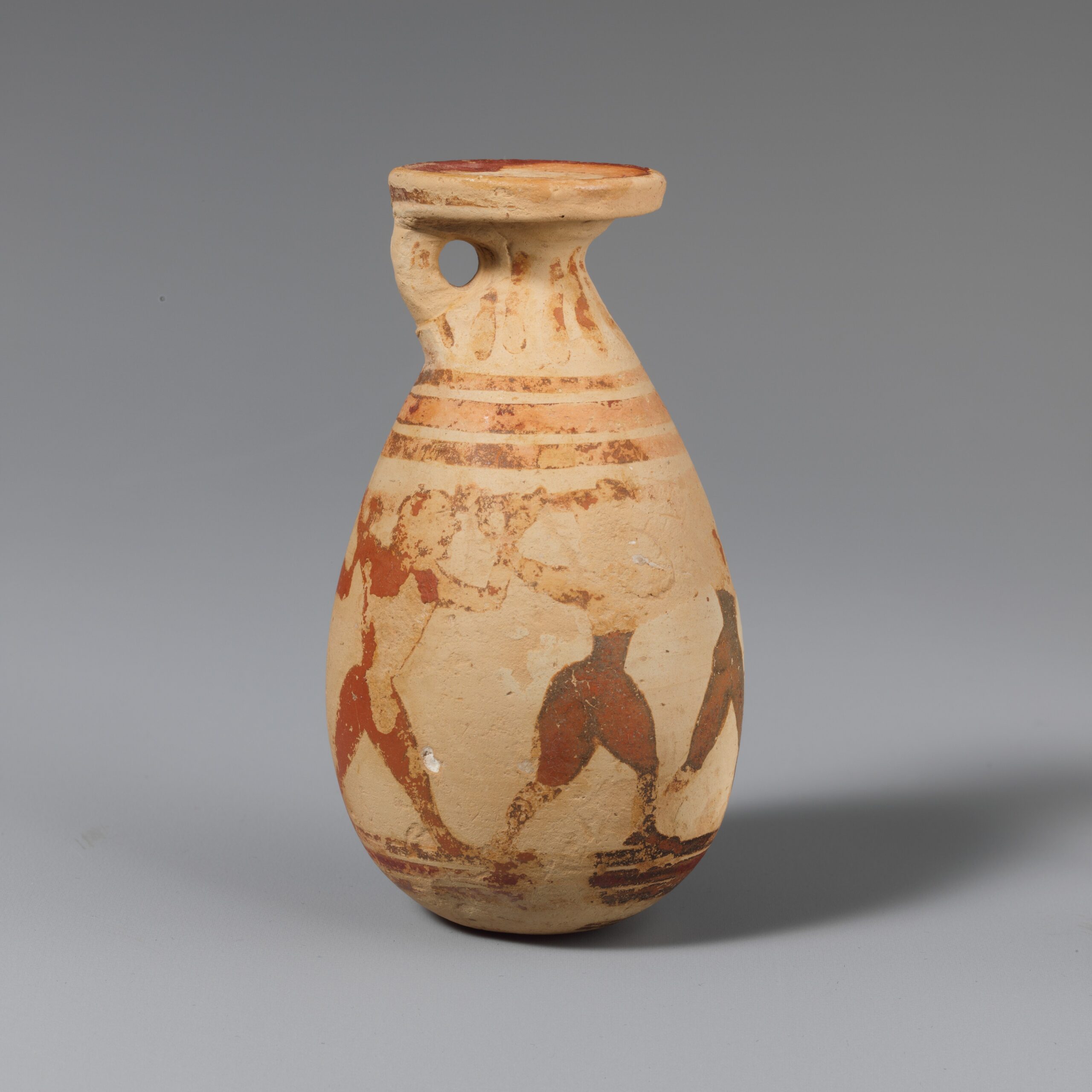 Petit vase à parfum en terre cuite décoré de silhouettes noires : des hommes enfoncent un long pieu dans l’œil d’un géant.