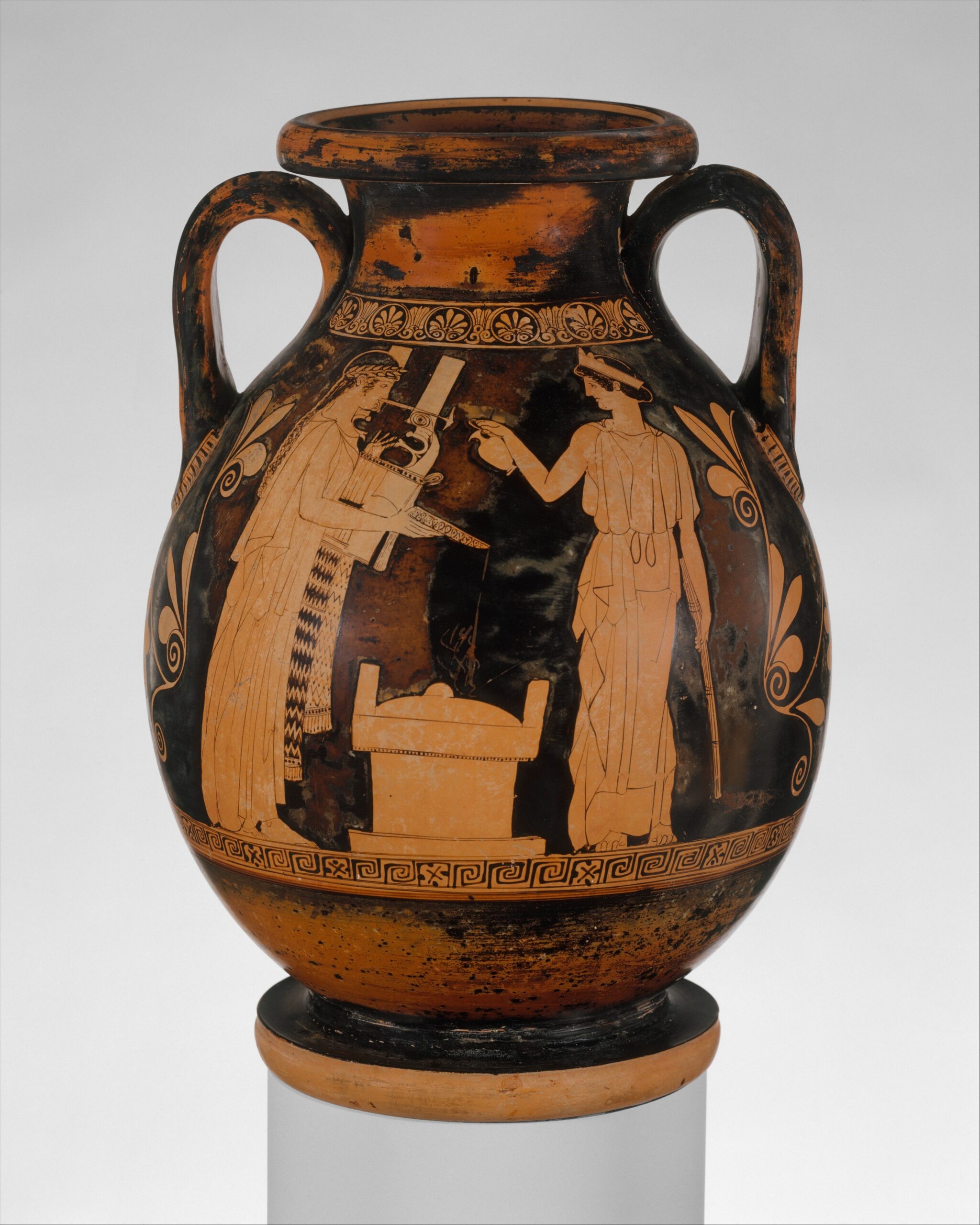 Vase grec à figures rouges montrant deux personnages de part et d'autre d'un autel, l'un tenant un instrument à cordes et une coupe, l'autre versant un liquide.