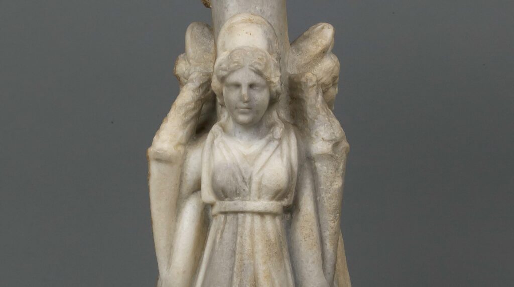 Petite sculpture de marbre : trois figures féminines drapées, adossées à une colonne centrale, tournées dans trois directions.