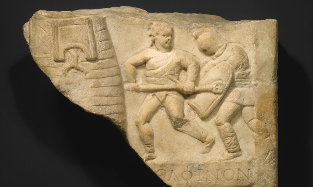 Fragment de relief en marbre : deux gladiateurs en mouvement, l'un armé d'un trident et sans casque, l'autre casqué le poursuivant.