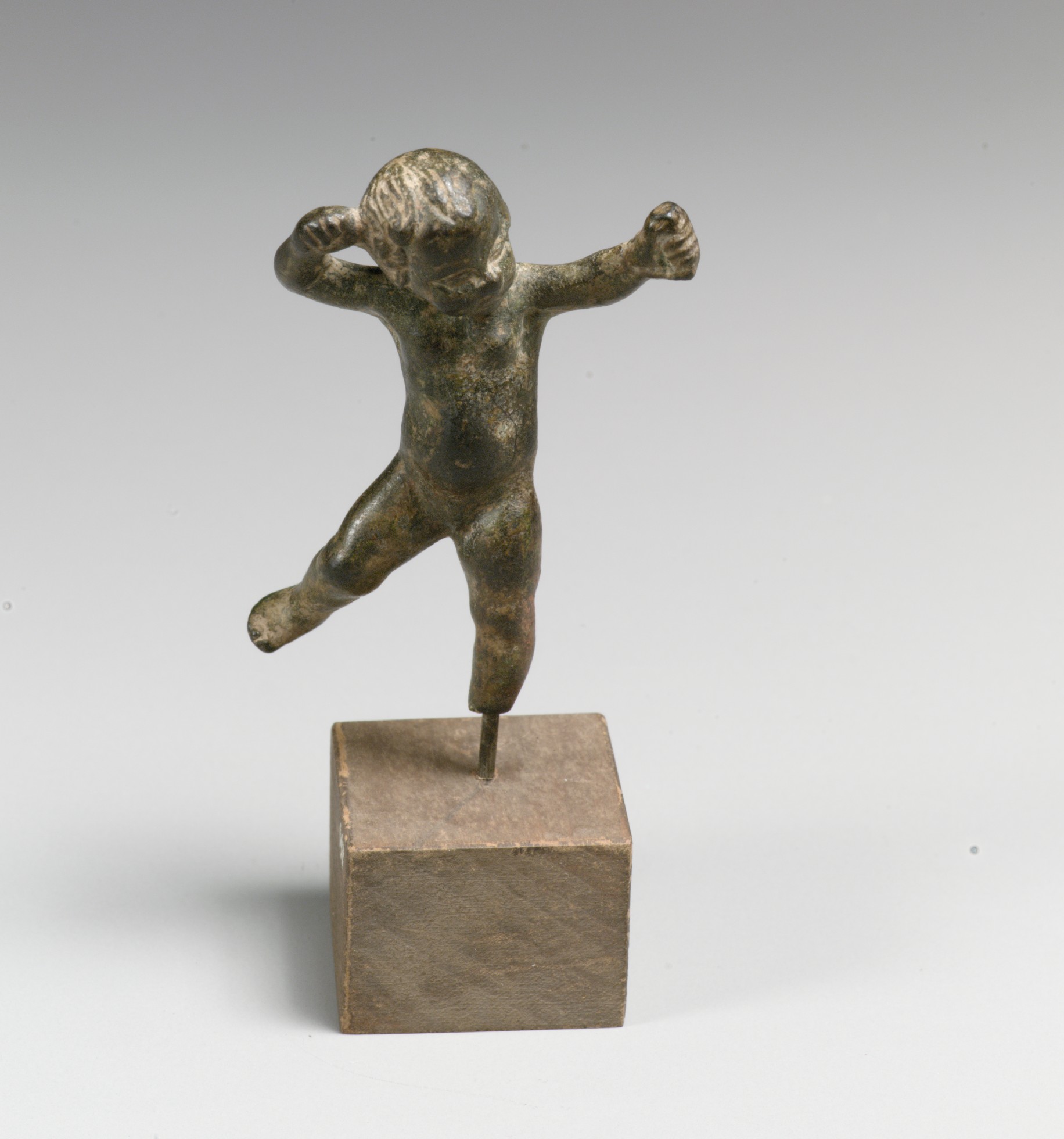 Petite statuette de bronze : un enfant nu et ailé.