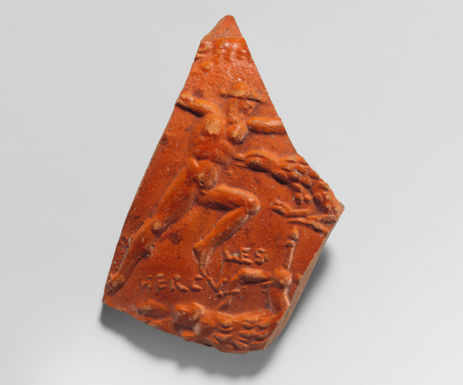 Fragment de médaillon en terre cuite rouge : en haut, un homme enchaîné, les bras écartés, un aigle à la poitrine ; en bas, un homme vêtu d’une peau de lion tient un arc, à côté de l’inscription HERCULES.