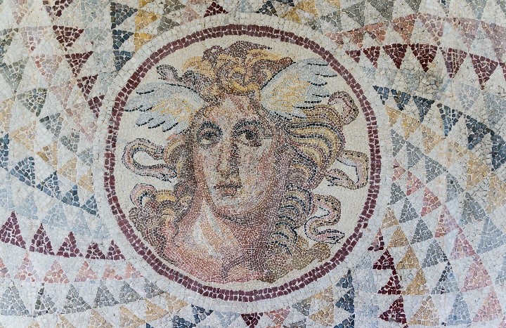Mosaïque polychrome : tête de Méduse, la chevelure mêlée de serpents, au centre d'un encadrement géométrique.