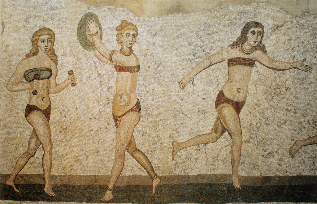 Mosaïque de sol en deux registres : des jeunes femmes vêtues d'un deux-pièces s'exercent au sport, l'une avec des haltères, d'autres au lancer ou à la course ; l'une d'elles tient une couronne et une palme.