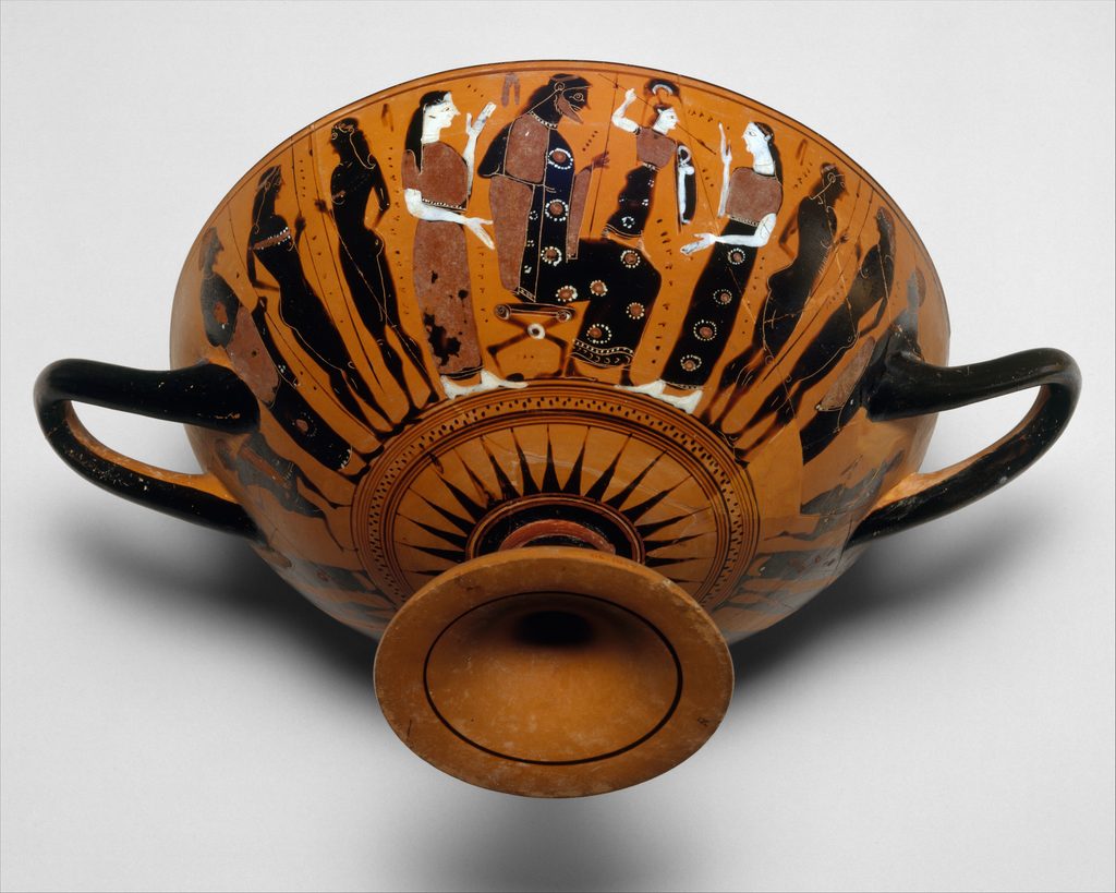 Coupe grecque à figures noires : une petite figure armée jaillit de la tête d'un homme assis, entouré de plusieurs personnages debout.