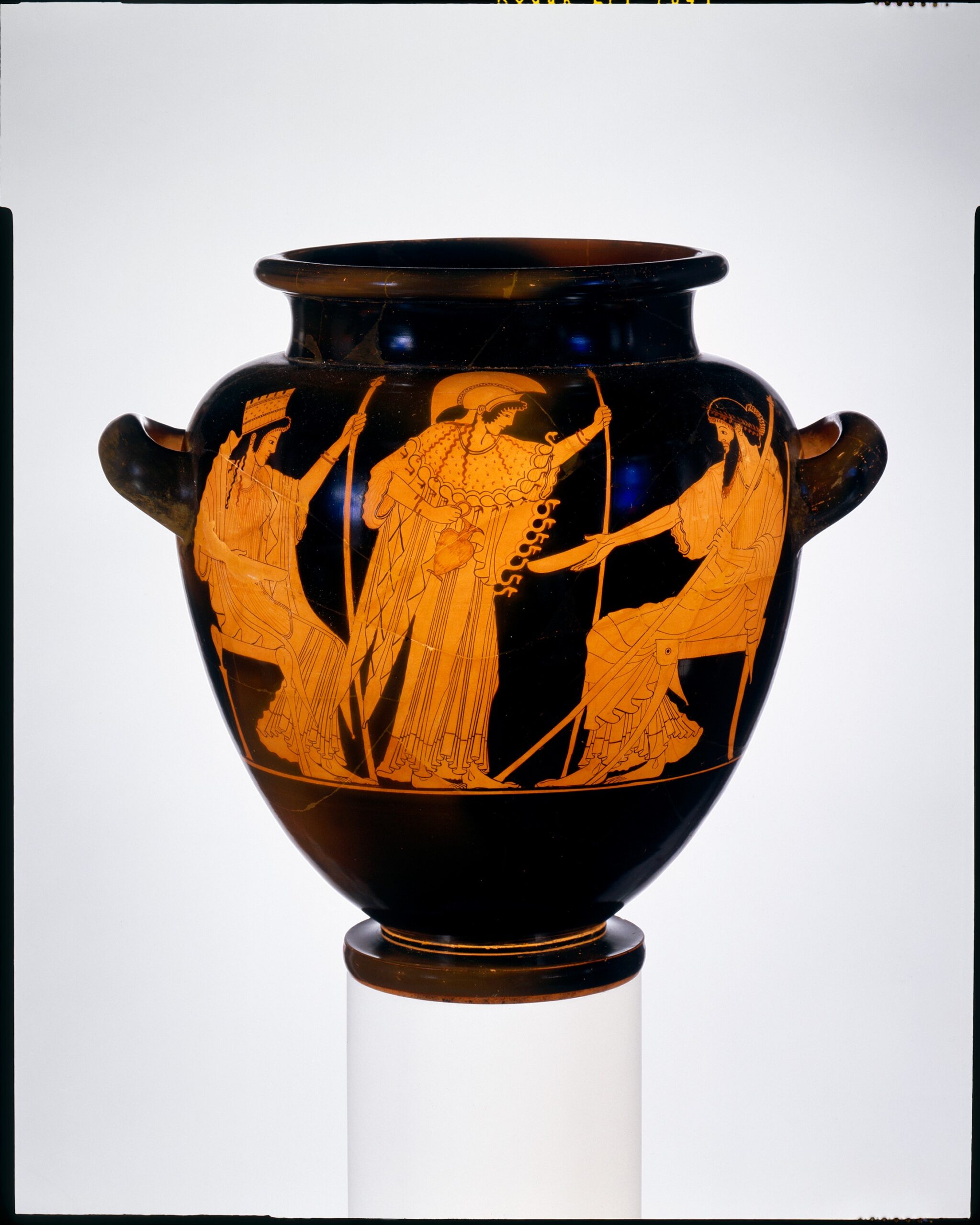 Vase grec à figures rouges : trois divinités debout, celle du centre casquée tenant une cruche, les deux autres présentant des coupes.
