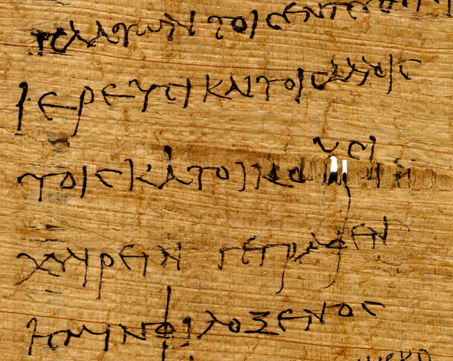 Détail d'un papyrus : une interruption dans les fibres horizontales laisse apparaître les fibres verticales de la couche inférieure, sur lesquelles trois lettres grecques ont été tracées.