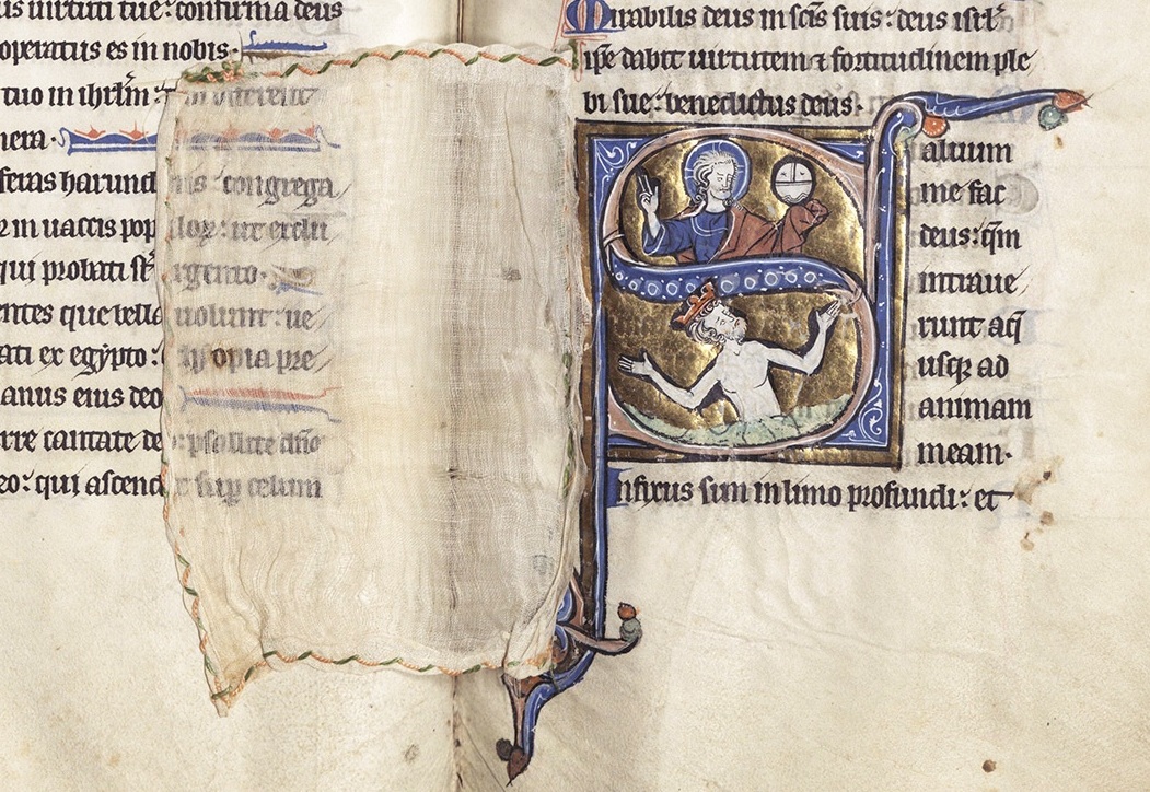 Voile de tissu translucide posé sur une page de psautier, laissant transparaître le texte et une initiale historiée dorée.