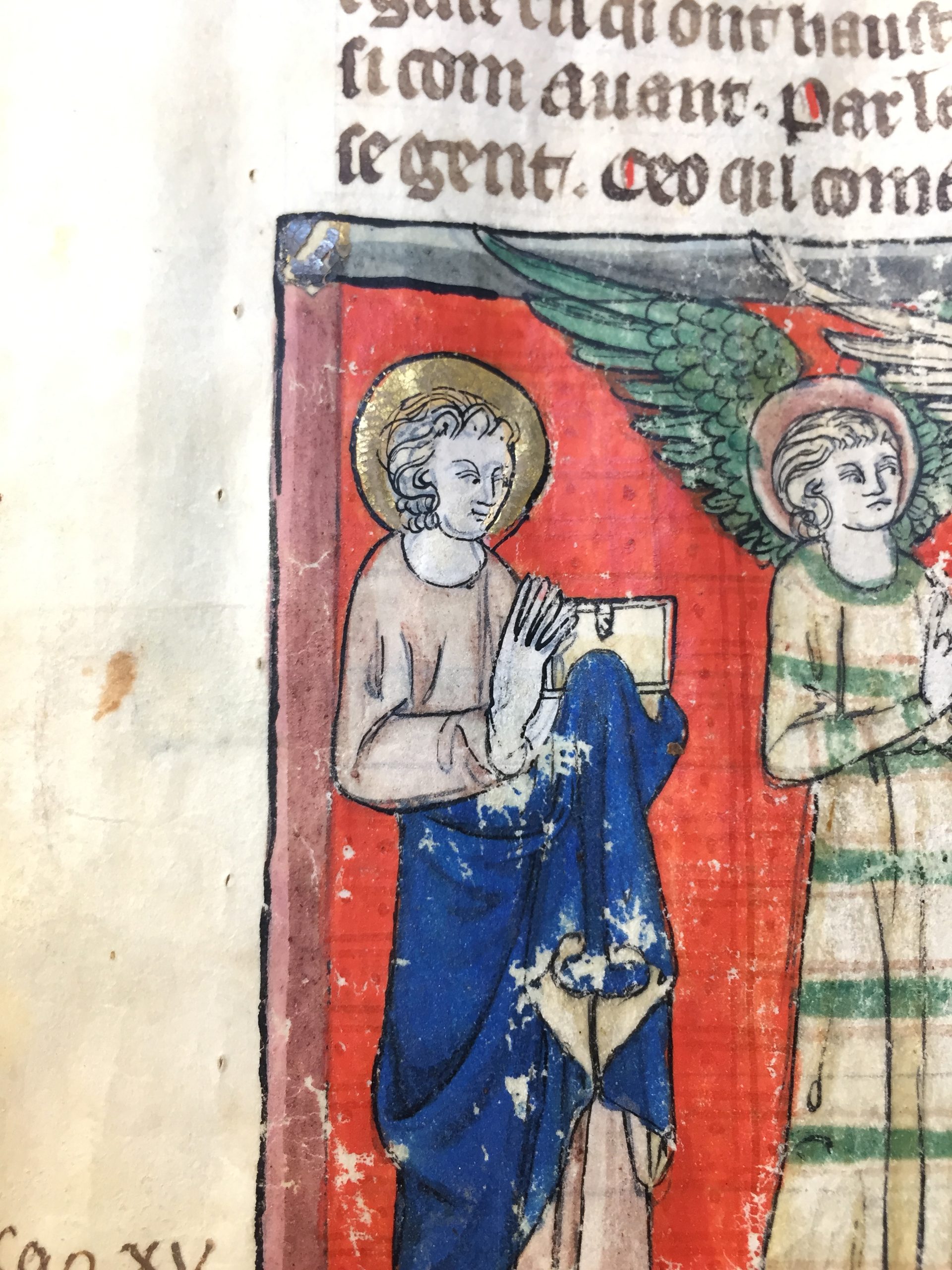 Bord supérieur d'une page de manuscrit percé de petits trous alignés, au-dessus d'une miniature à fond rouge.
