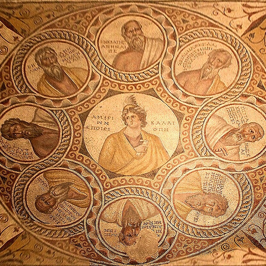Mosaïque circulaire aux tons ocre : une figure féminine au centre, entourée de huit médaillons représentant des hommes barbus, chacun accompagné d'une inscription en grec.
