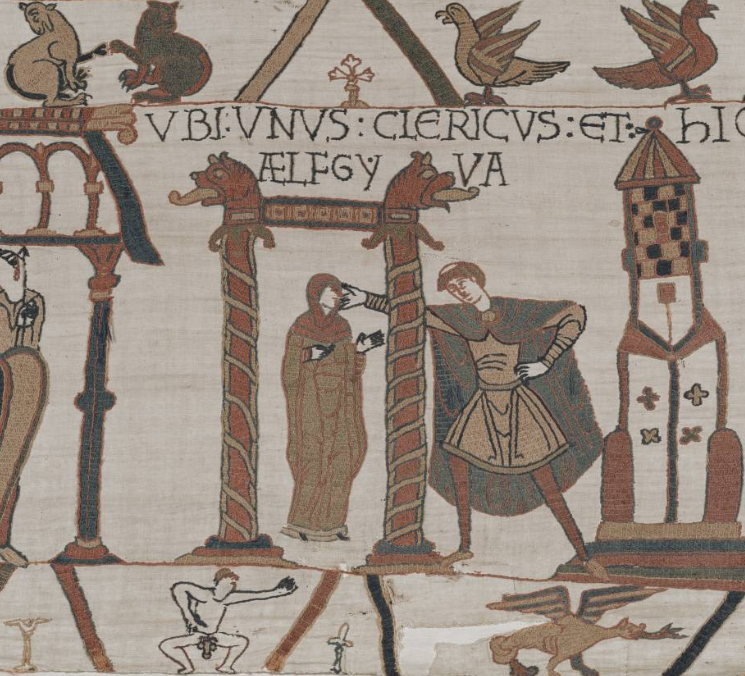Détail de broderie montrant une femme debout sous un portique, un homme tendant la main vers son visage, avec une inscription latine au-dessus.
