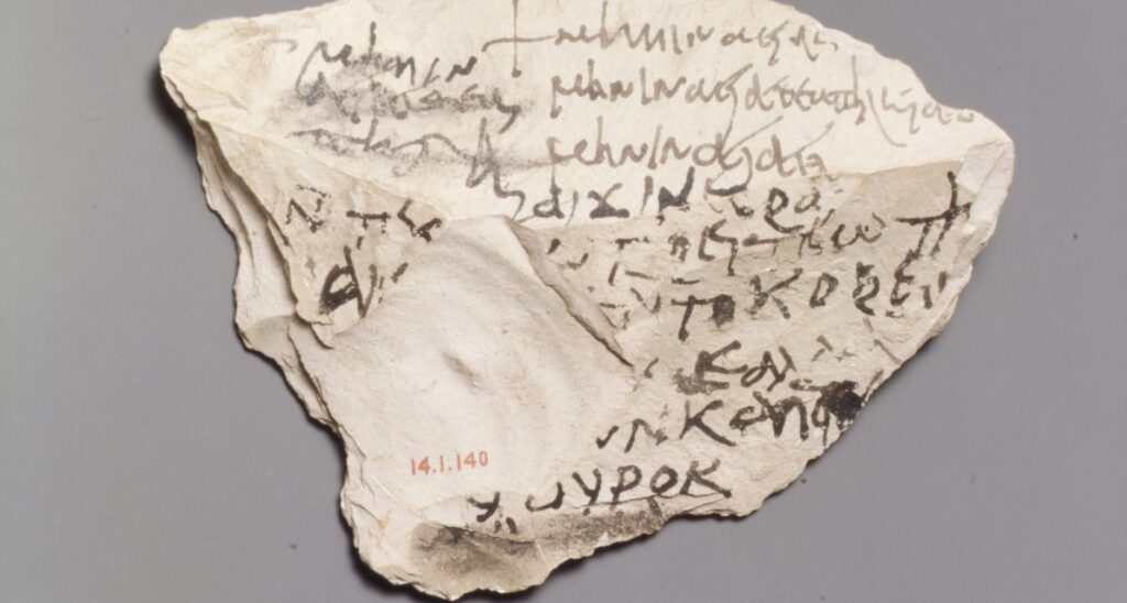 Tesson de calcaire portant quatre lignes d'écriture grecque à l'encre.