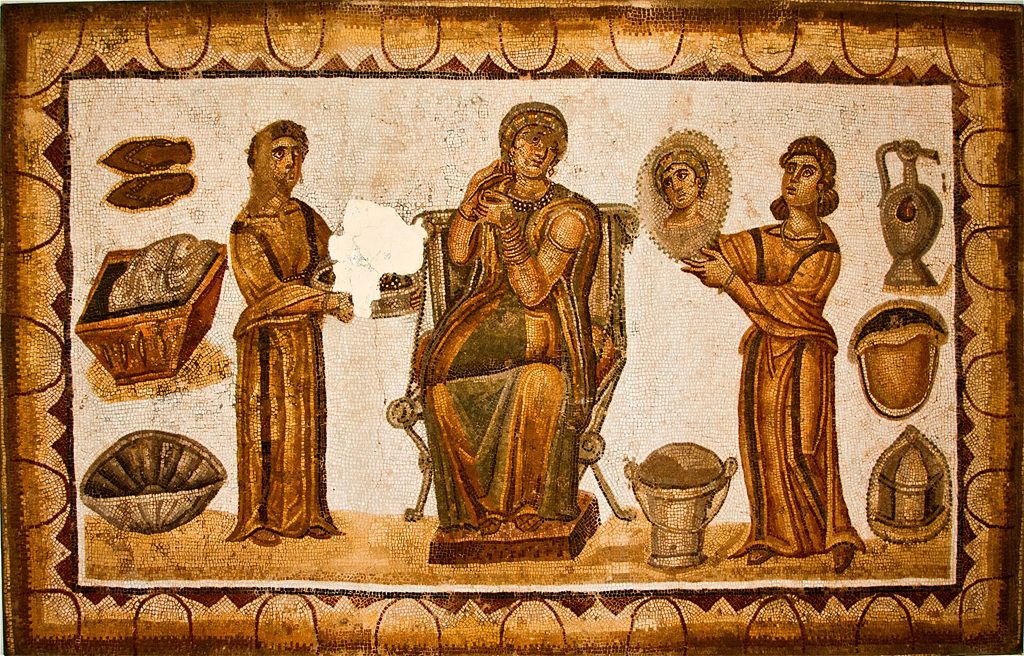 Mosaïque montrant une femme assise entourée de plusieurs servantes, avec des objets de toilette disposés autour d'elle.