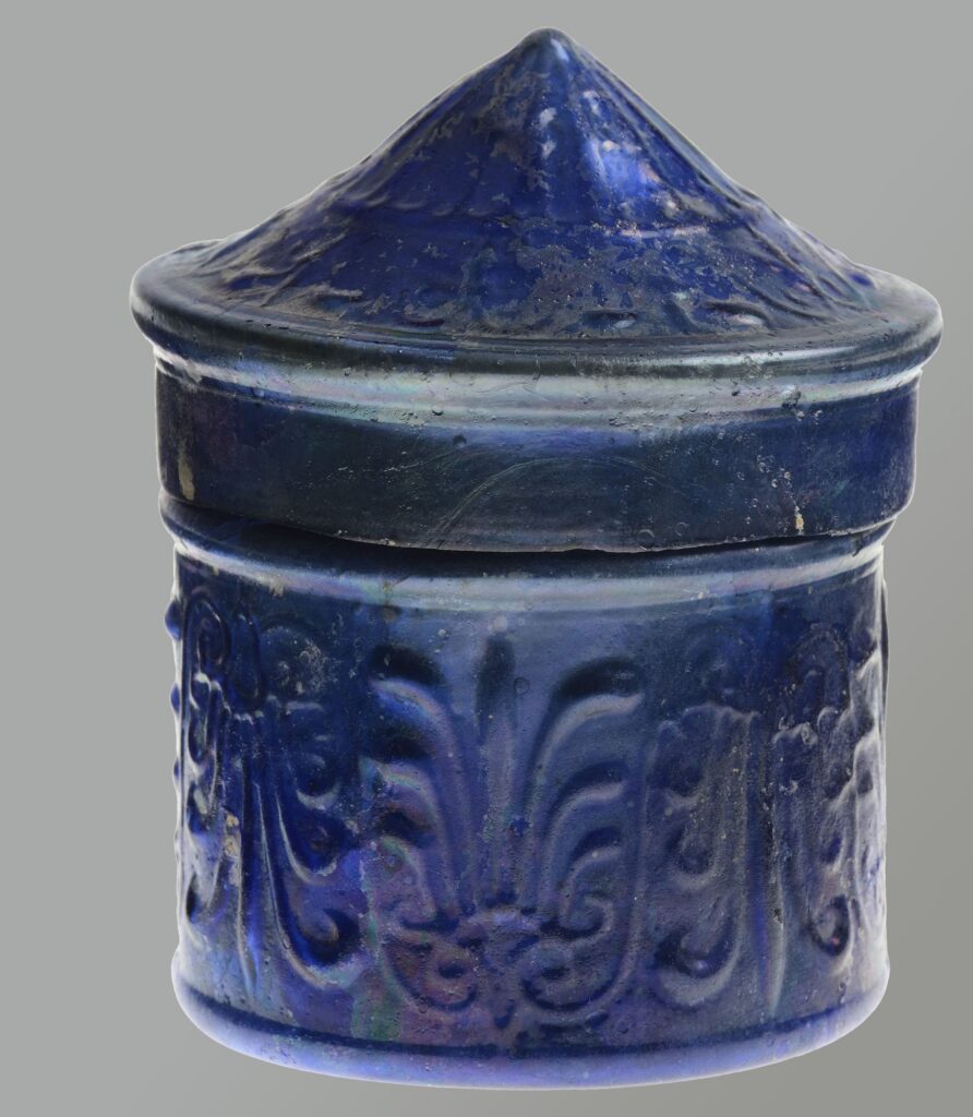 Petite boîte cylindrique en verre bleu foncé, munie d'un couvercle.